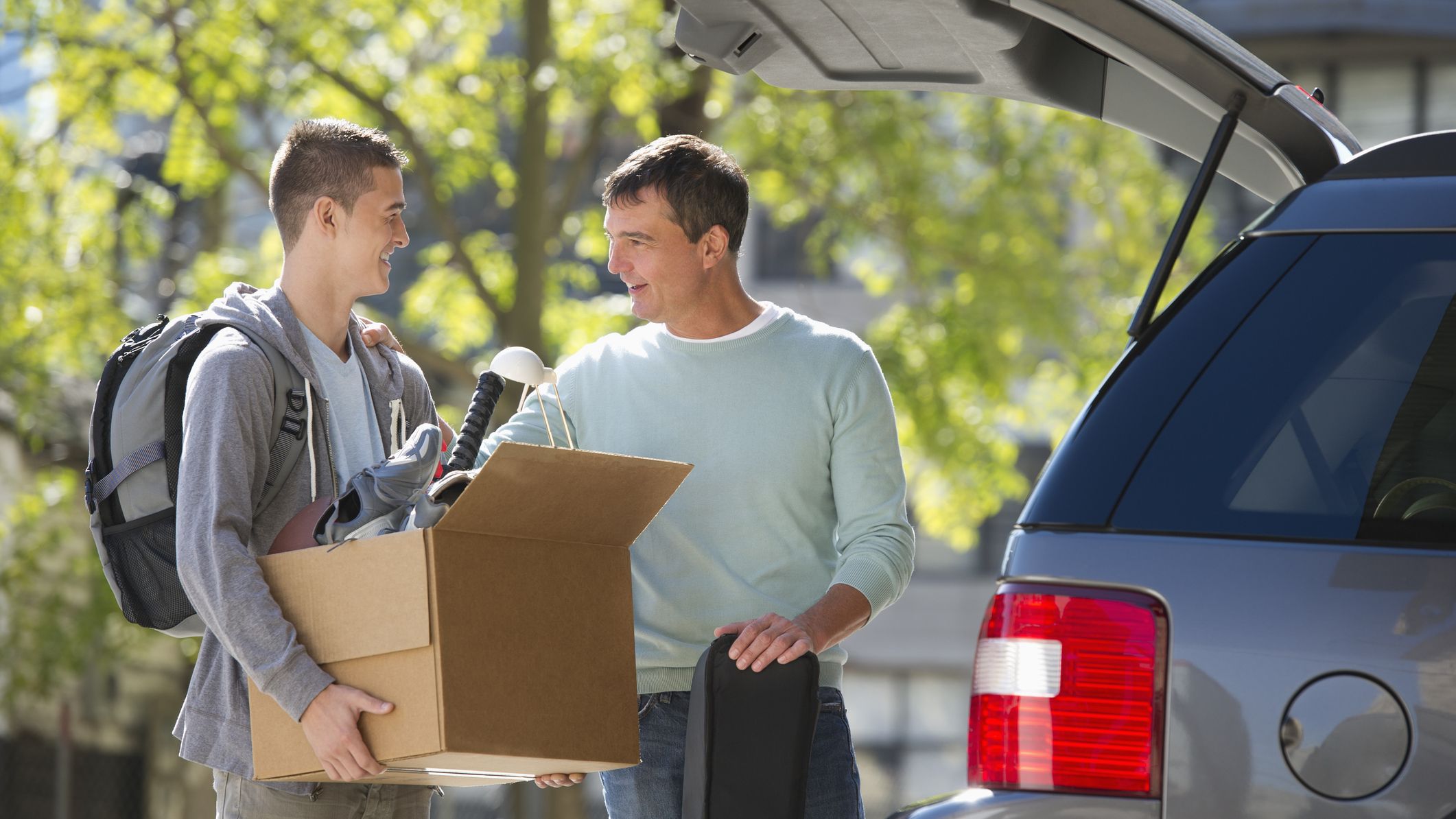 A father and son moving items to a college campus.