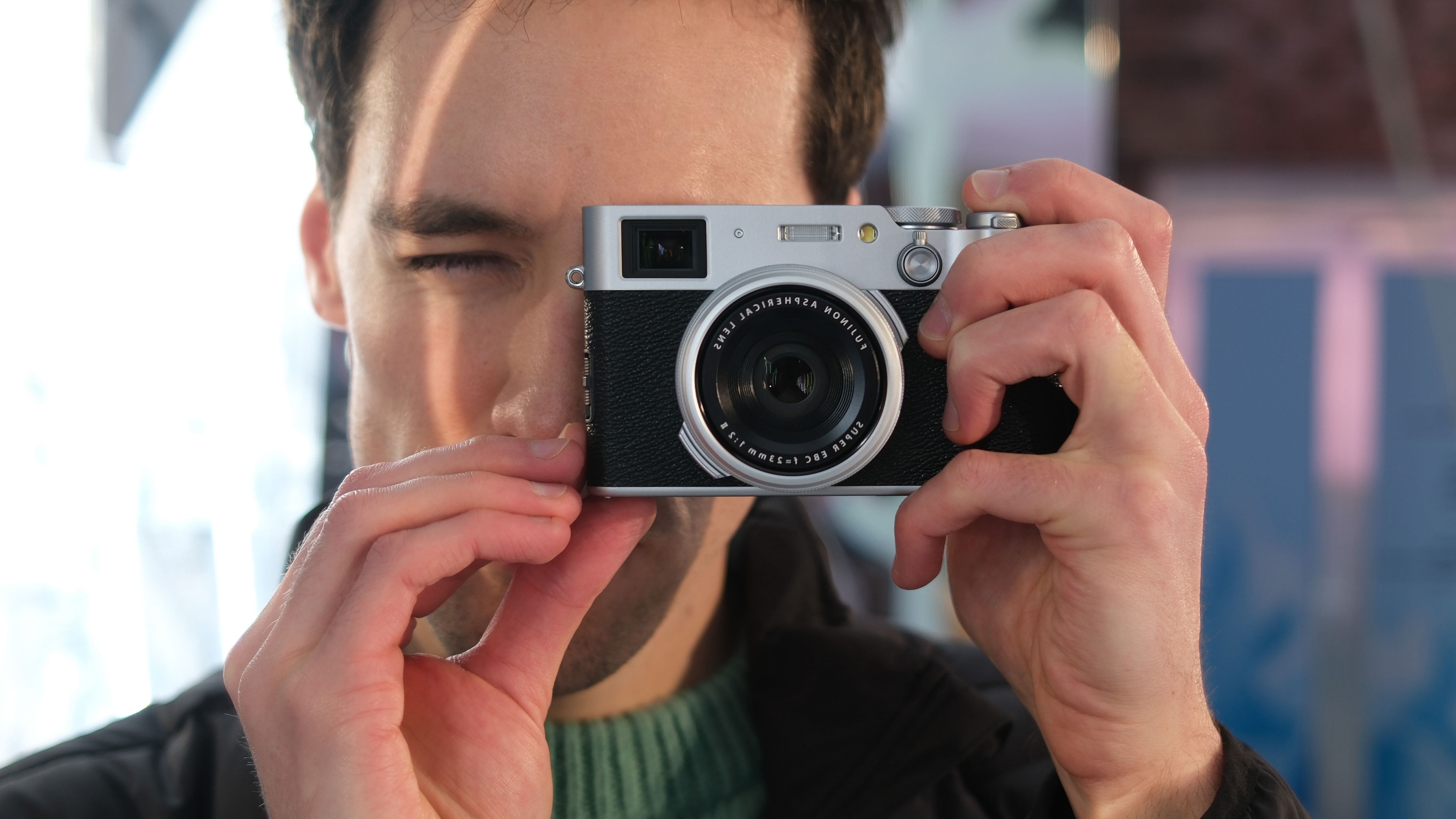 Fujifilm X100VI camera held up to a person's face