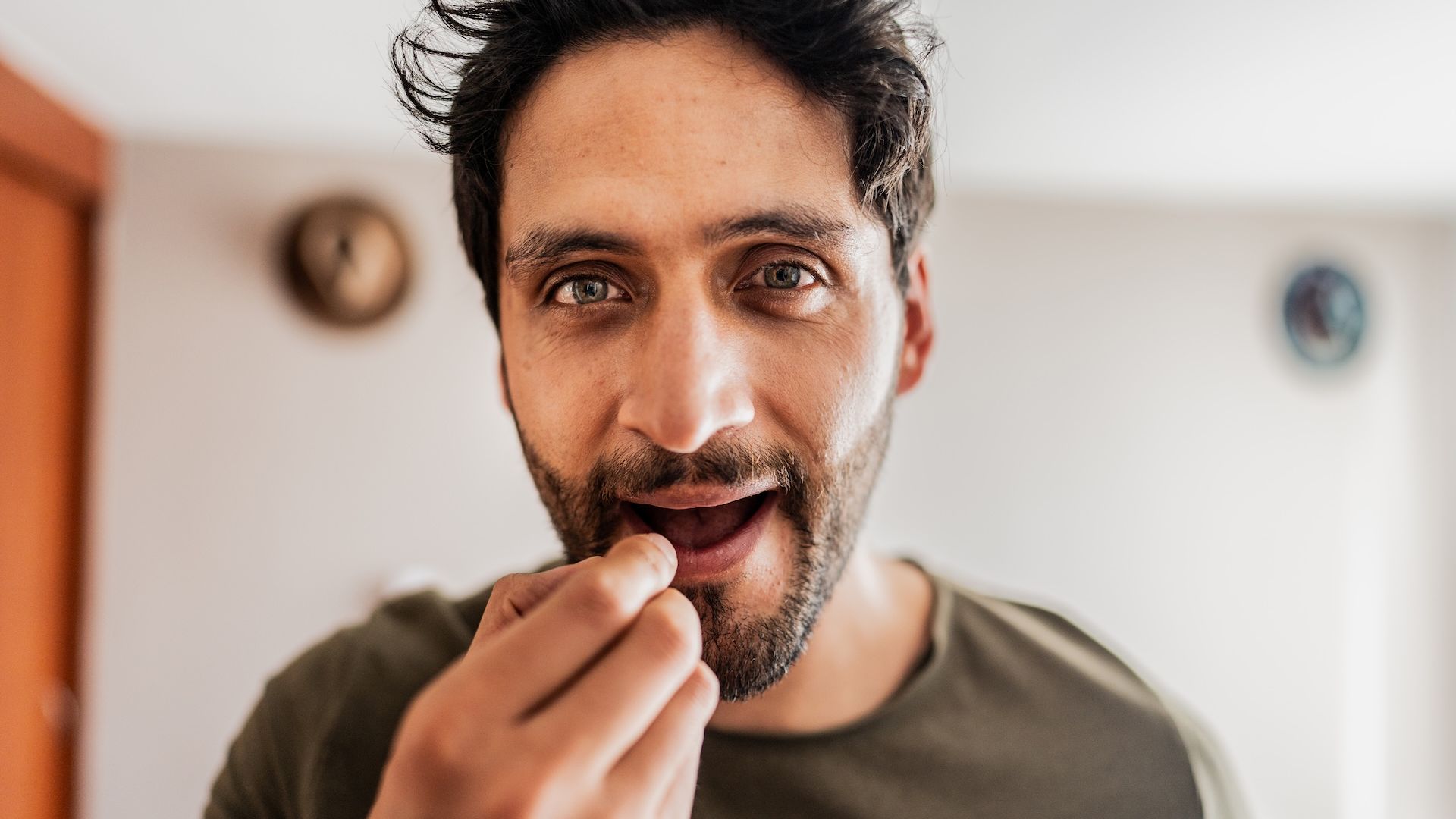 Mid adult man applying lip balm at home - camera point of view