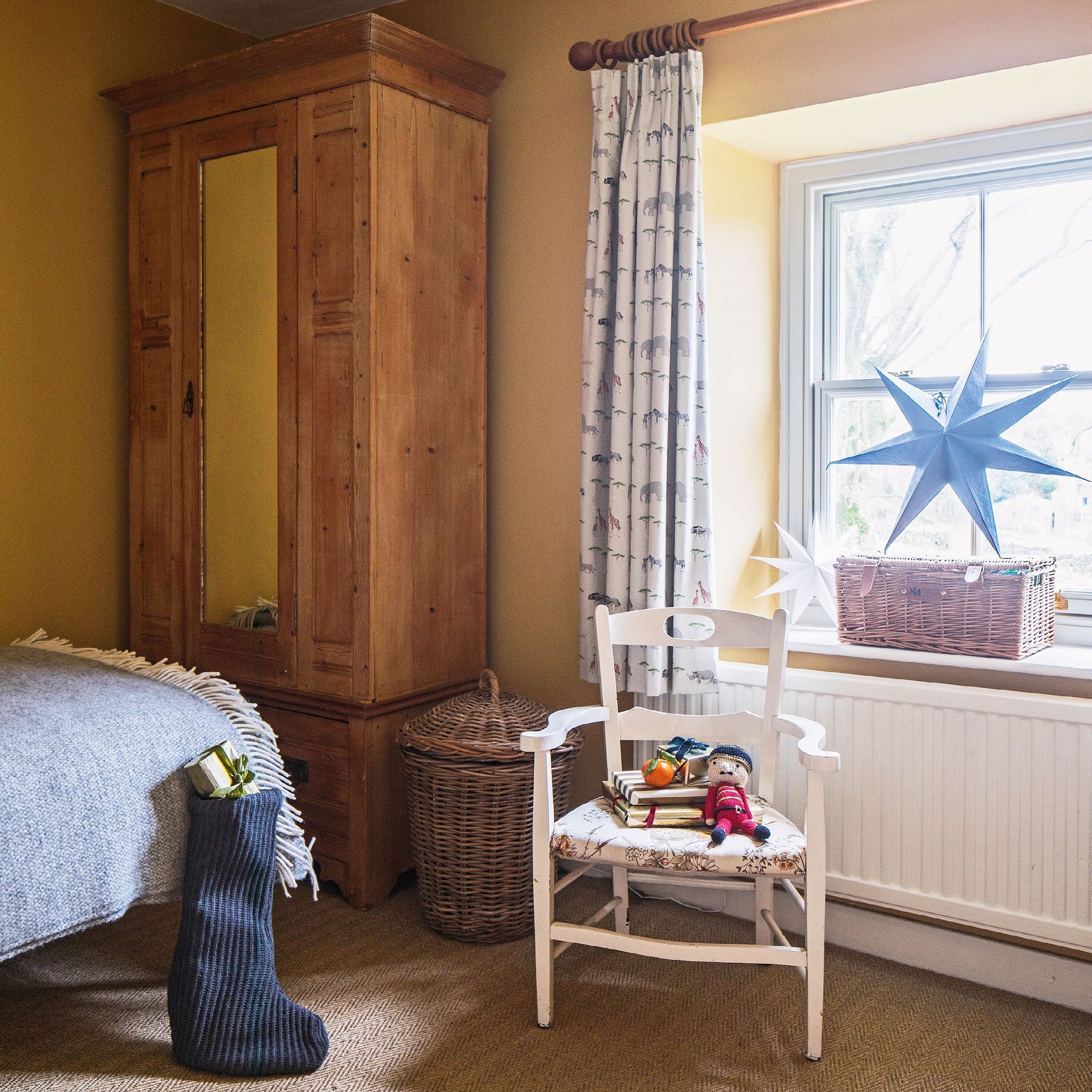 Children's bedroom in a country house dressed fr Christmas, with vintage chair and wardrobe