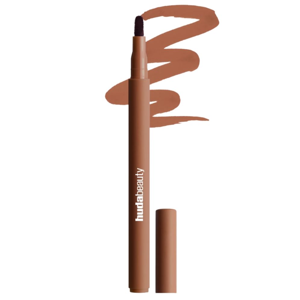 A product shot of the Huda Beauty Lip Contour Stain in shade Toasty Brown, alongside a swatch of the liner and on a white background