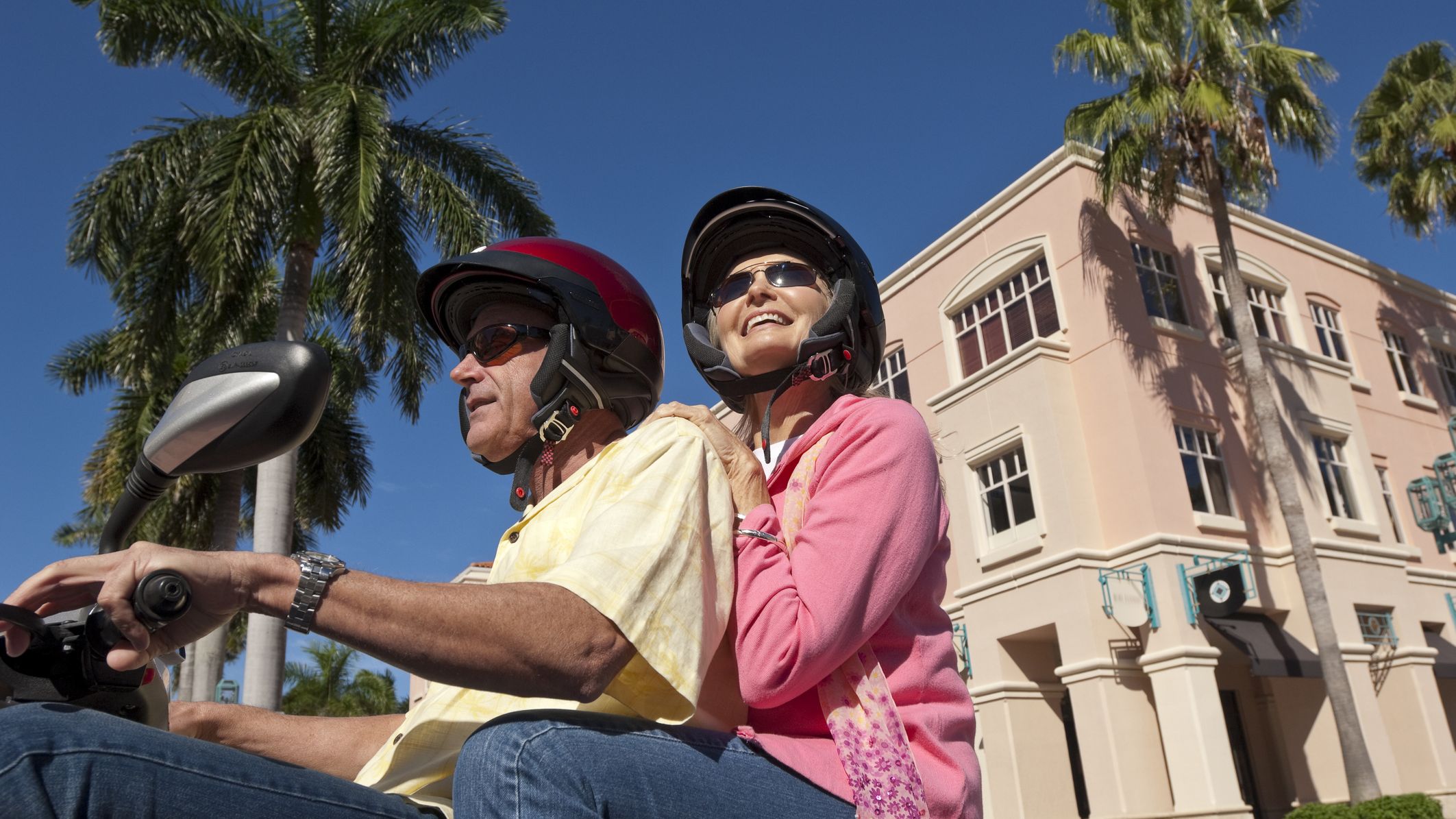 a happy couple taking a cruise on a scooter