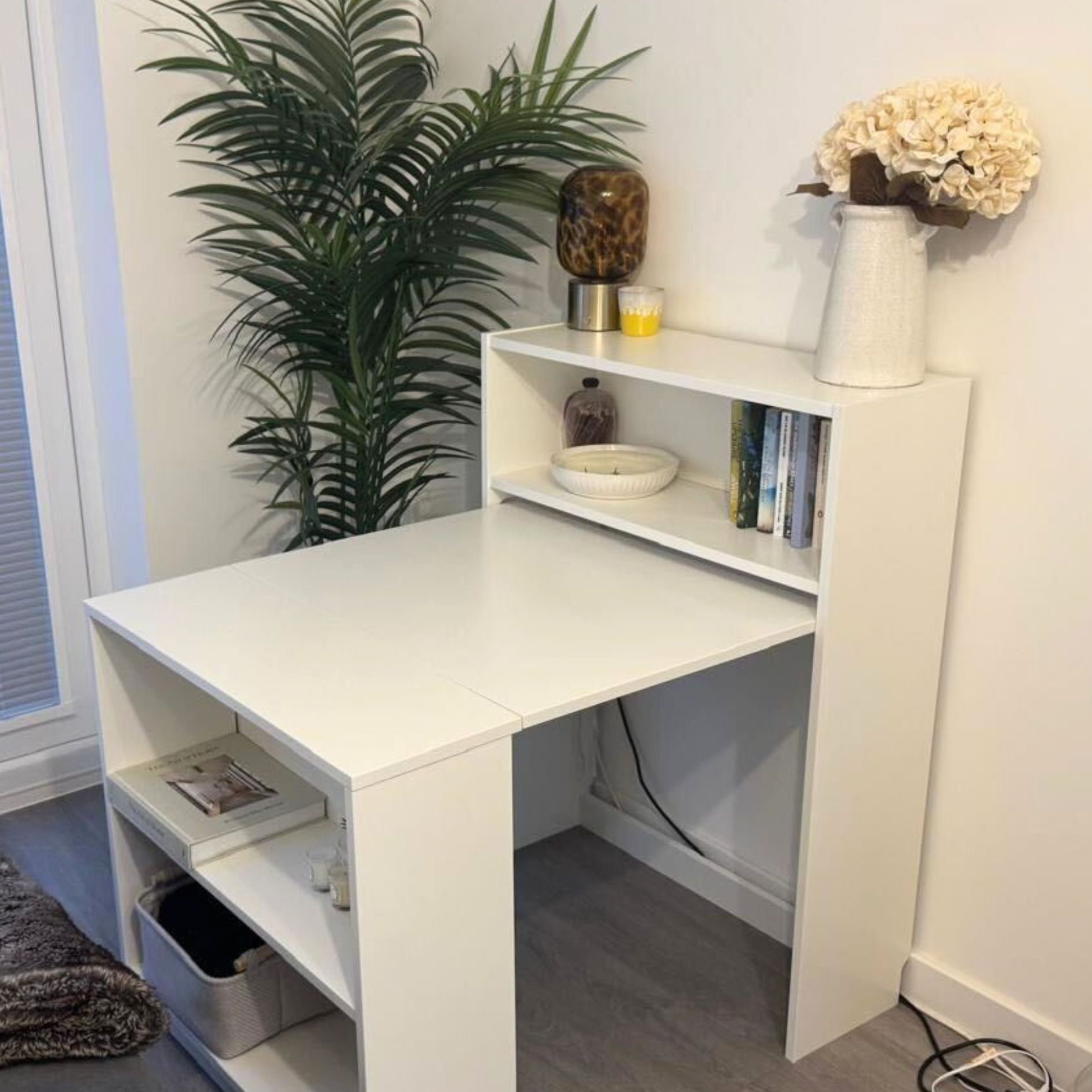 IKEA Billy bookcase extended out with desk, against a white wall