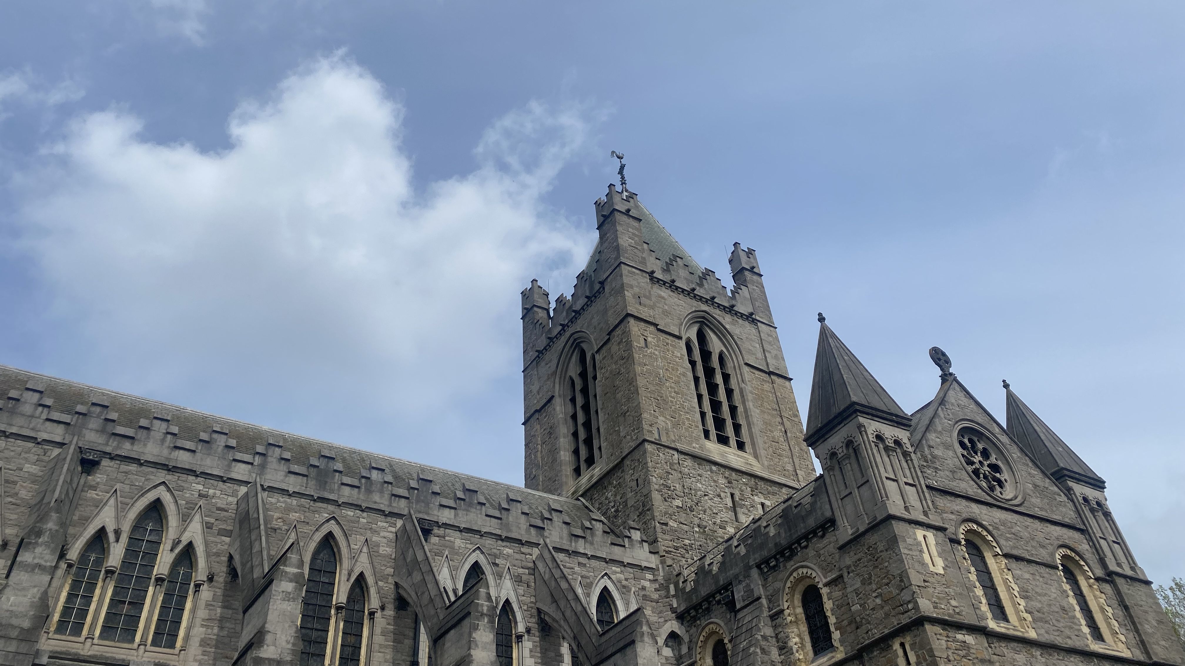 The top of Christ Church Cathedral in Dublin, with a blue sky and clouds.