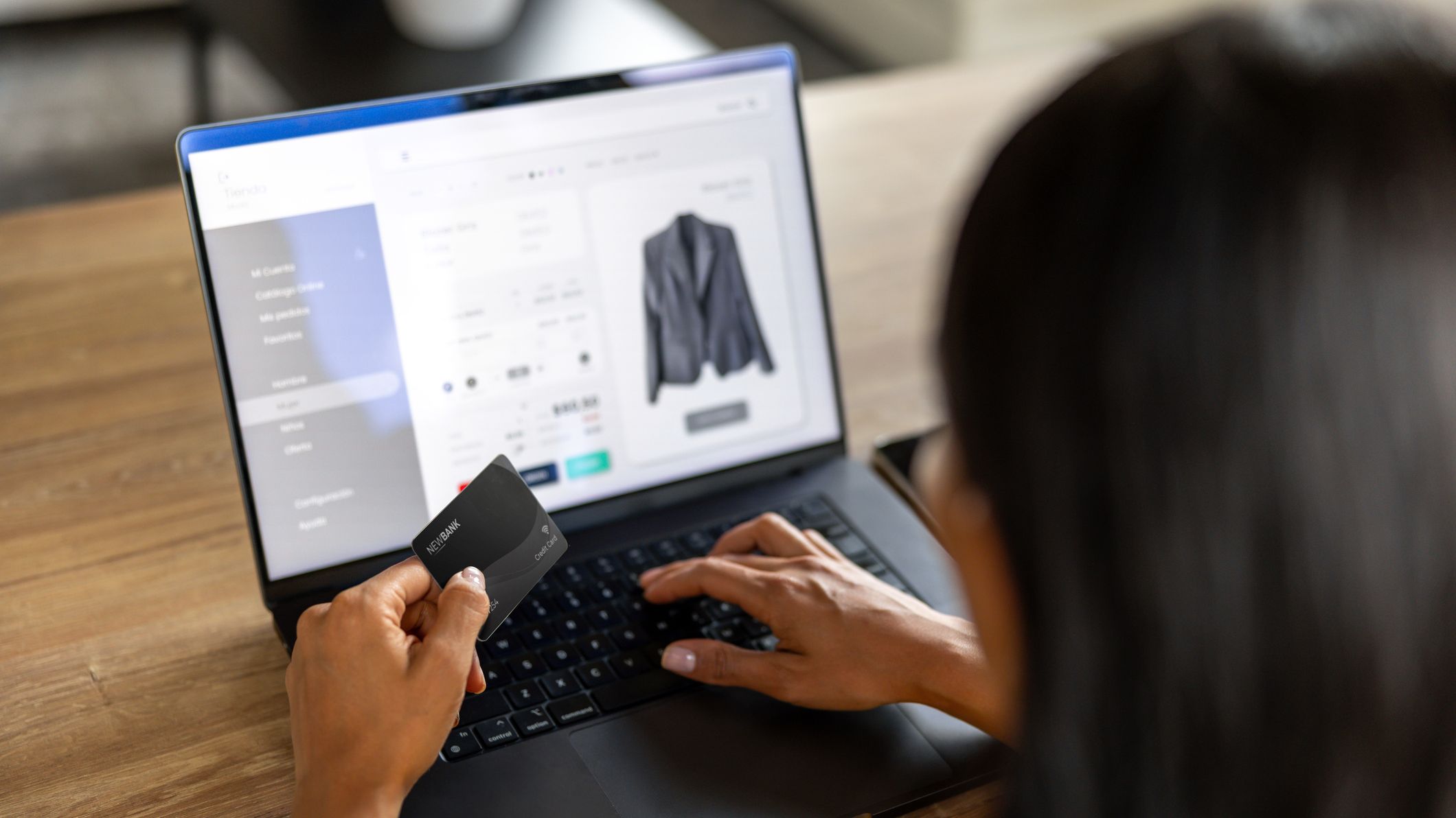 A woman online shopping with credit card in hand