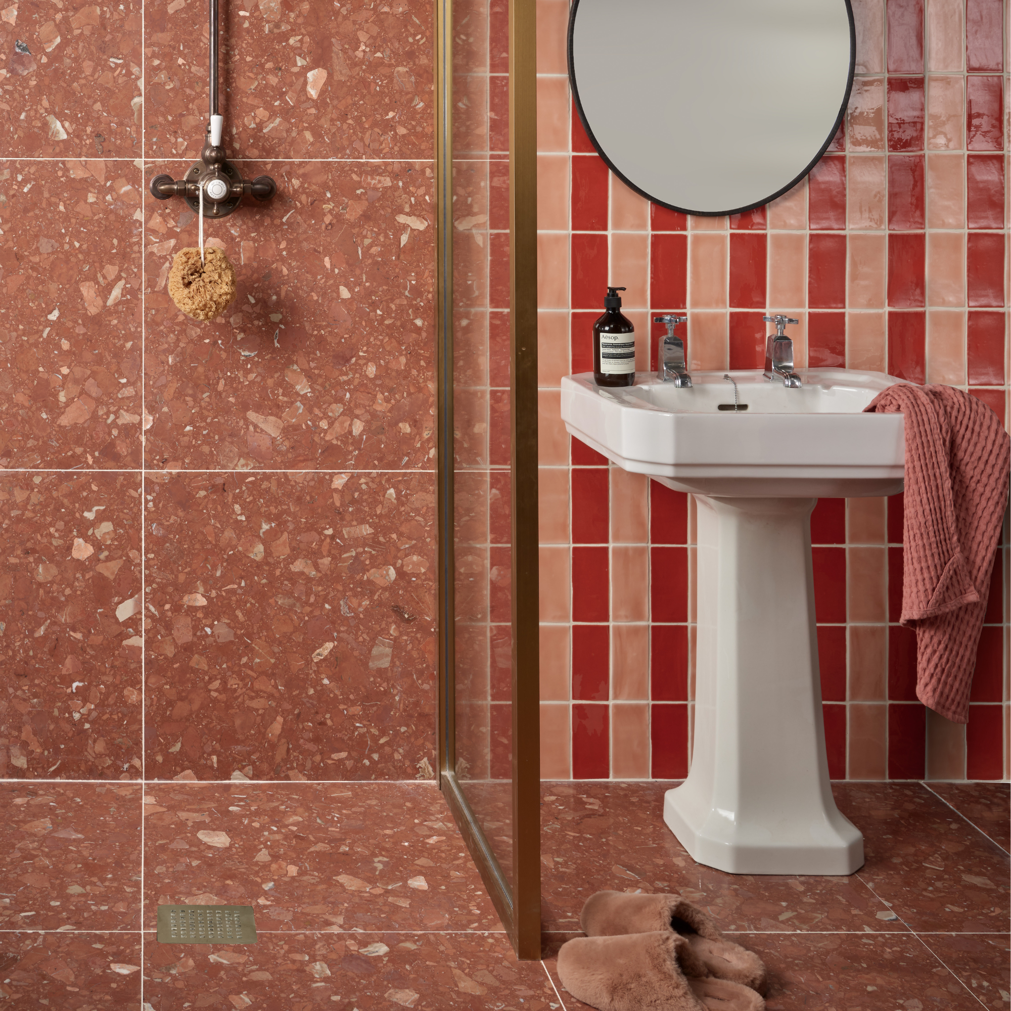 a brown bathroom with brown terazzo tiles and red and pink stripe tiles on the wall