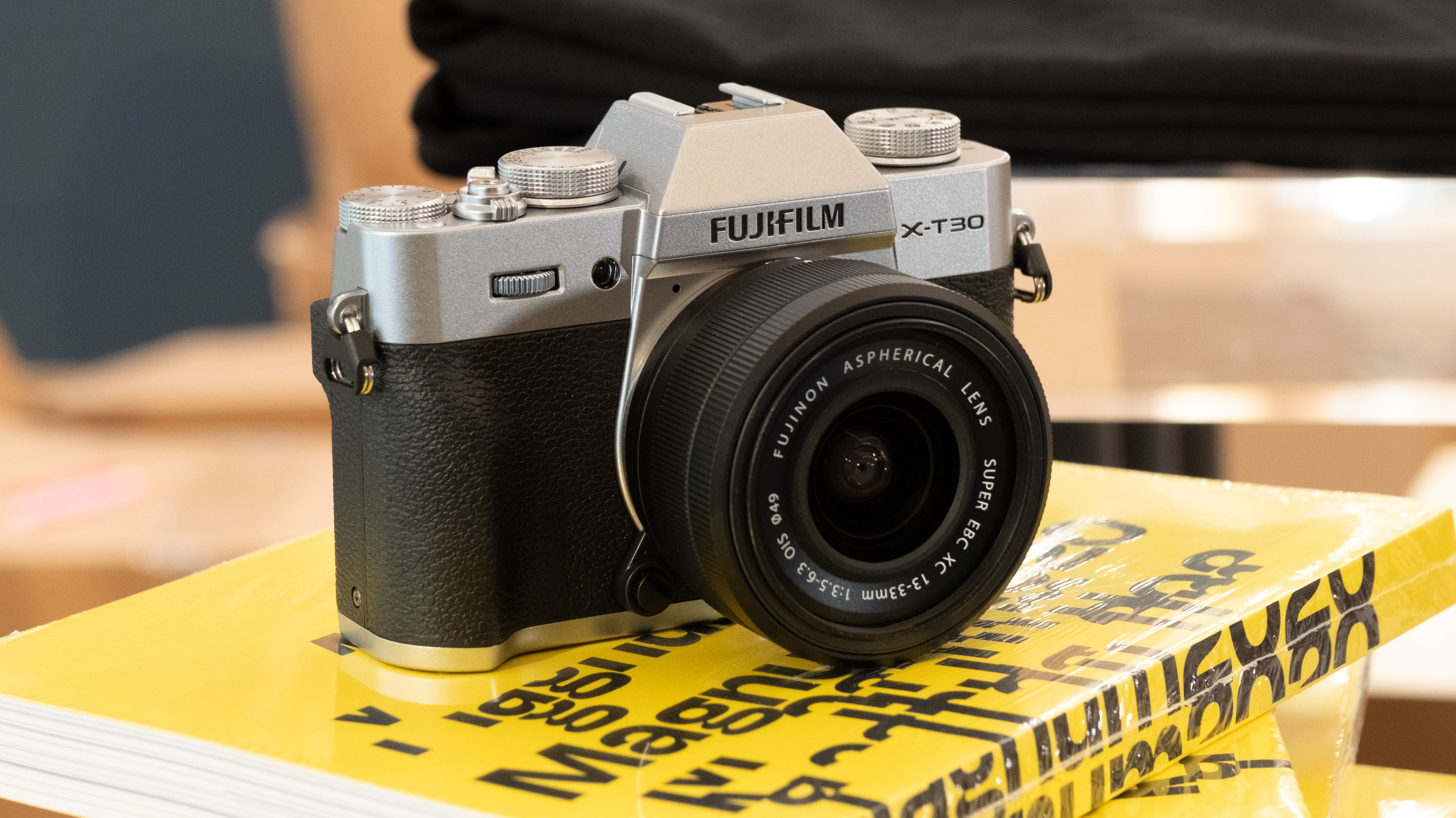 Fujifilm X-T30 III camera balanced on a stack of yellow books