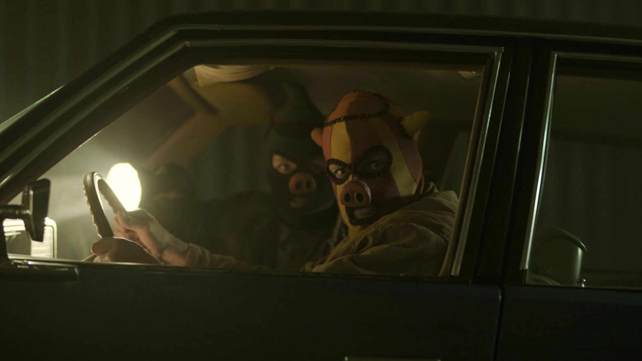 an image from the film which shows two attackers in kneecap-style masks looking out from inside a car