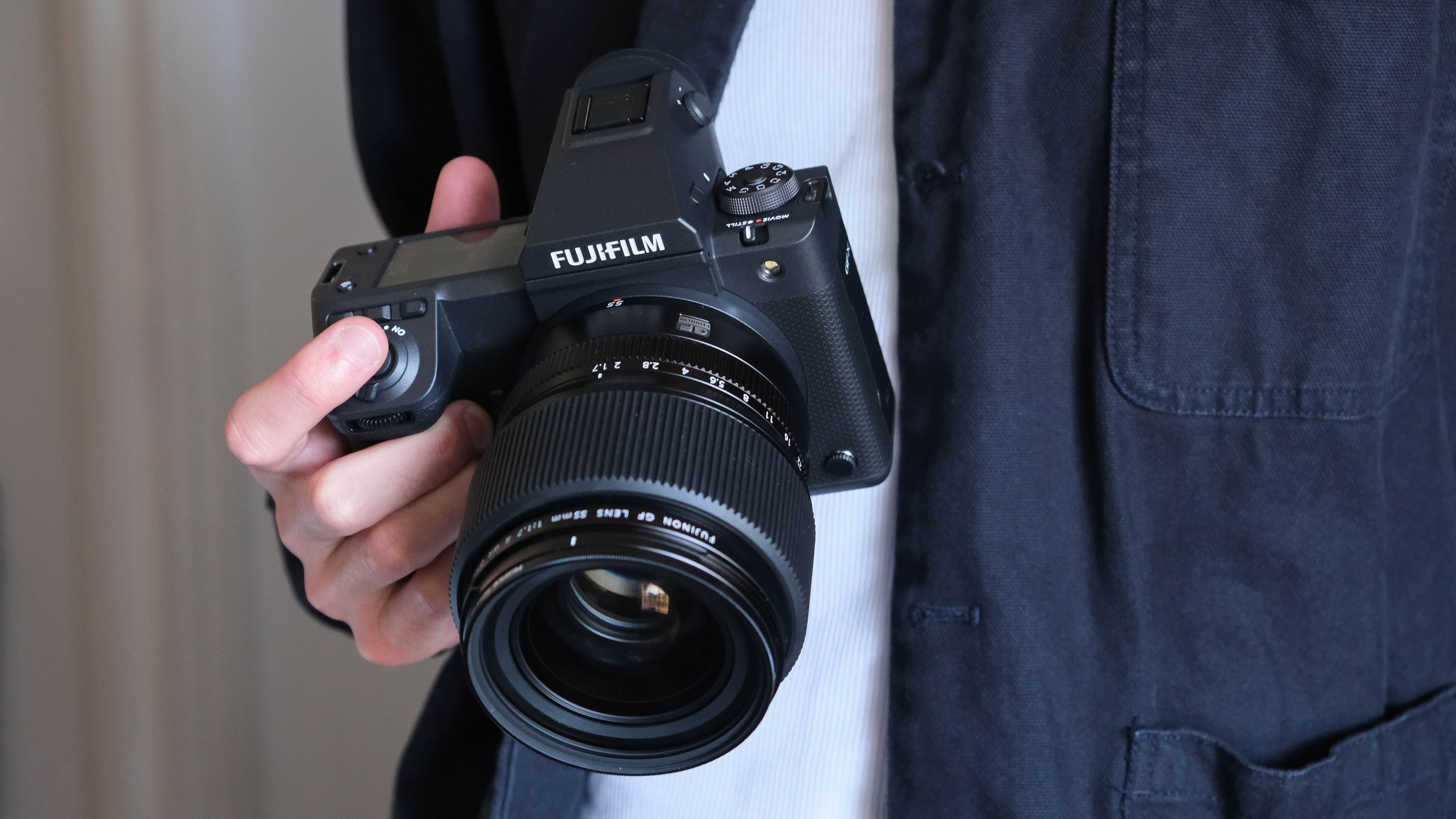 Fujifilm GFX 100 II camera with a lens held in a hand