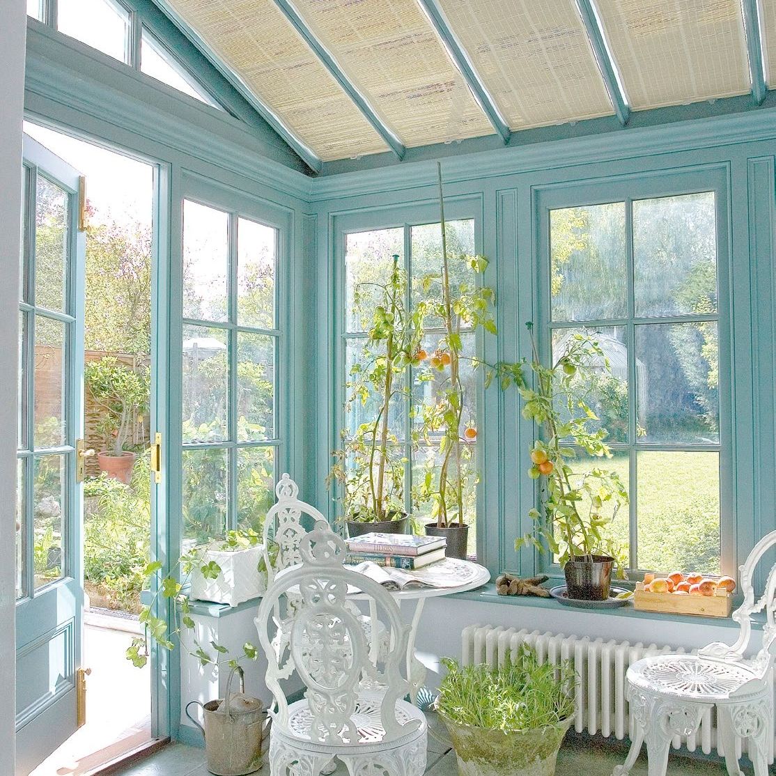 blue conservatory with jute roof blinds and white bistro-style furniture
