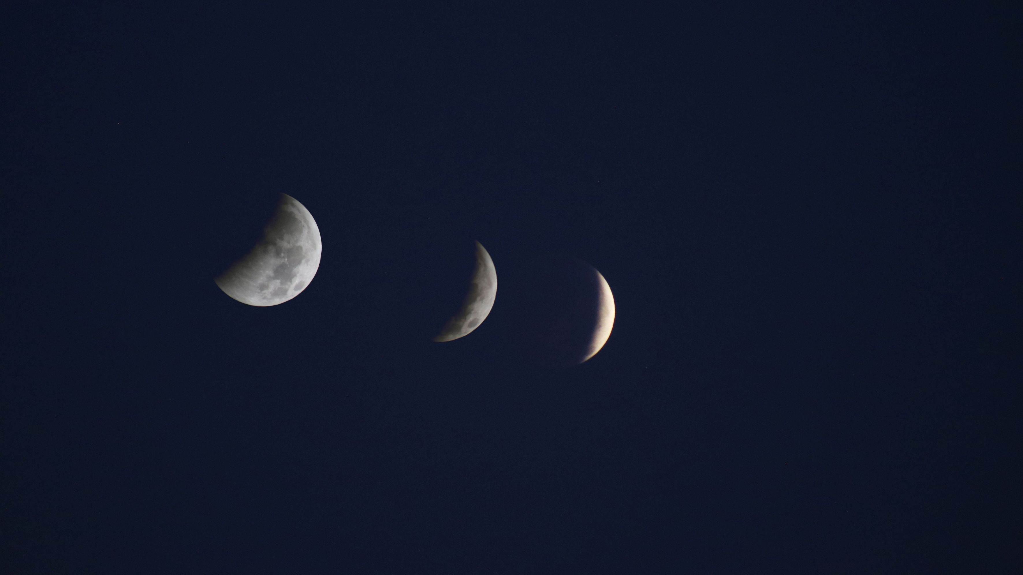 composite image showing stages of the partial lunar eclipse as the moon is covered by more and more of Earth's deep dark umbral shadow.