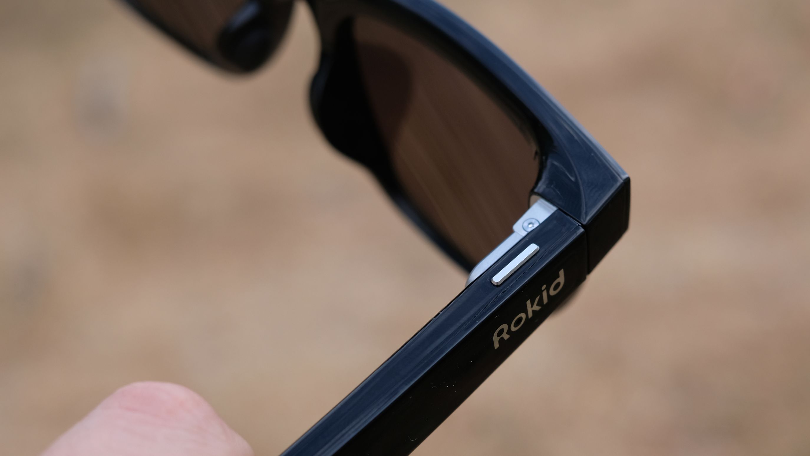 Hands-on photograph of Rokid AI Glasses Style close up on function button