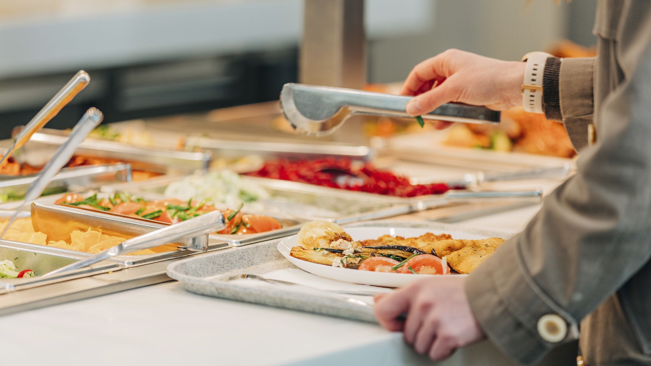 Woman puts food on her plate at the buffet