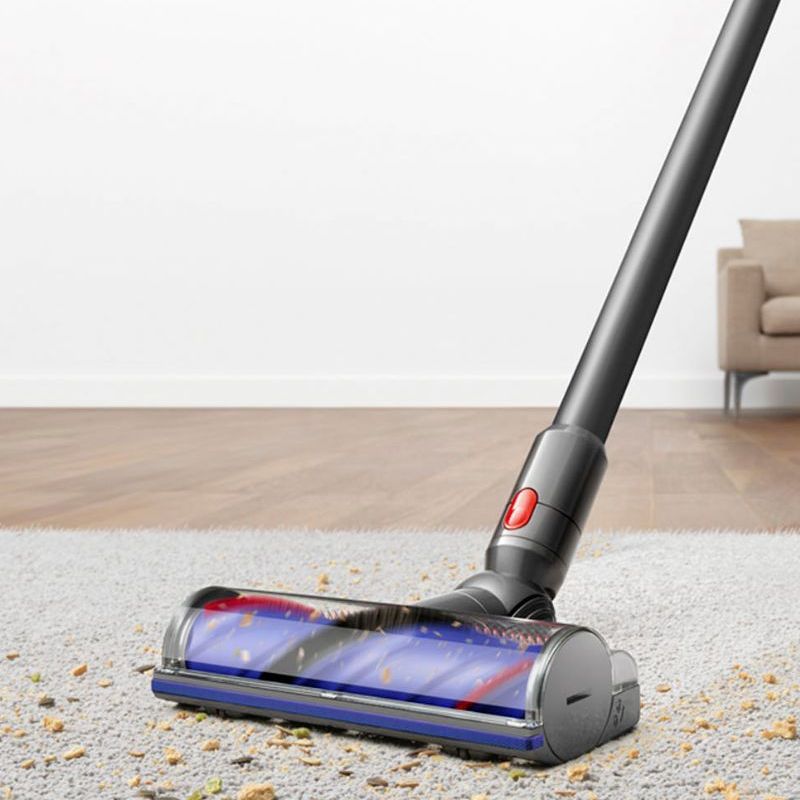 Dyson V10 vacuuming cereal and debris off a gray carpet