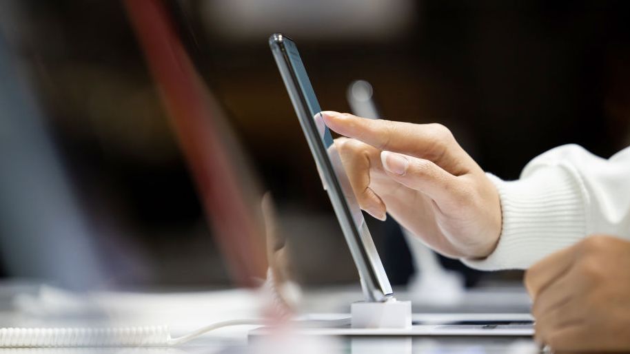 A person testing a smartphone in store.