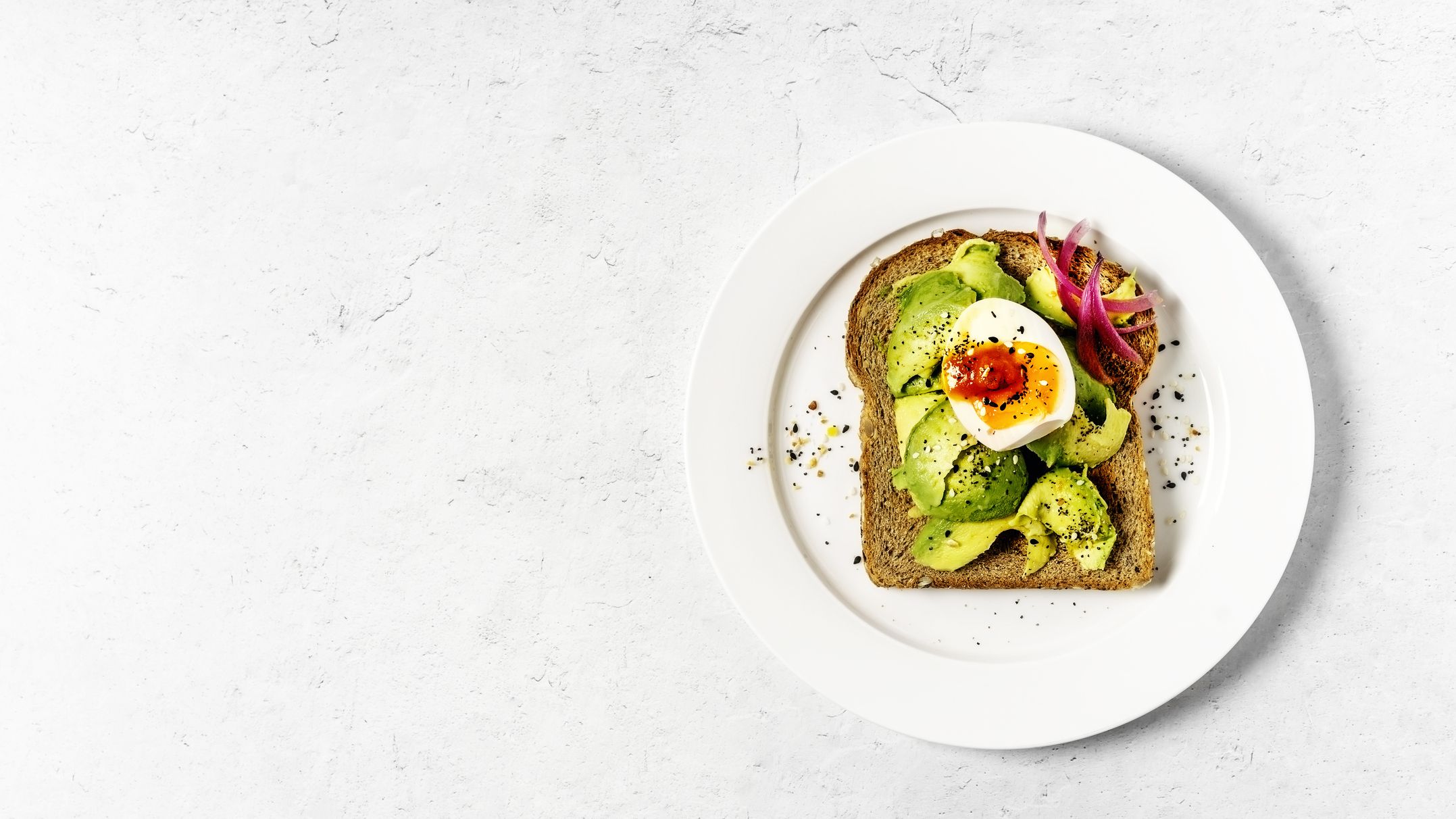 A plate with a fancy avocado toast and egg.