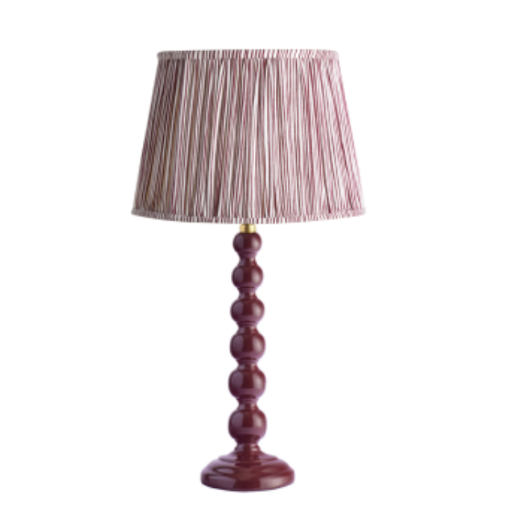 A burgundy bobbin lamp with a red and white striped shade