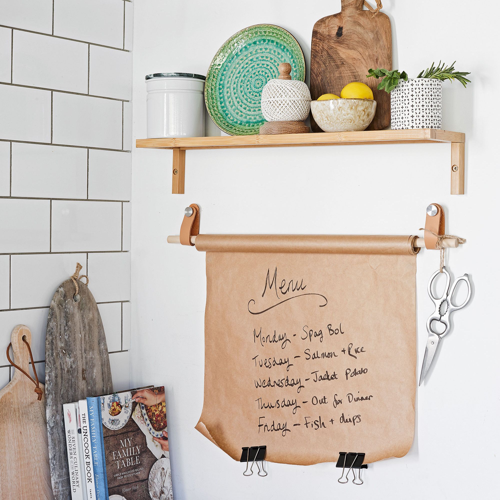 kitchen area with paper menu on wall and shelves with chopping boards
