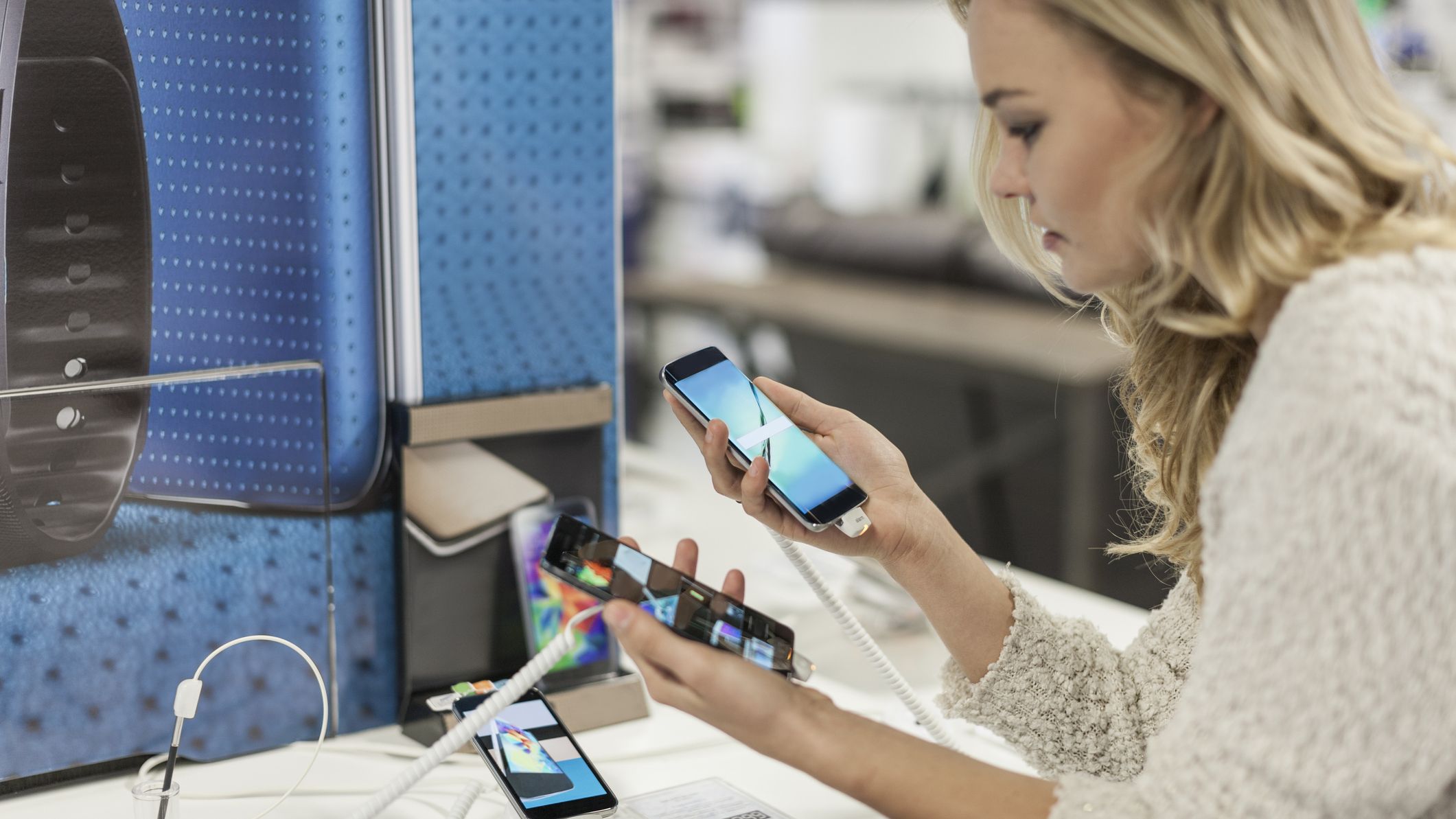 A woman comparing smart phones in a phone store