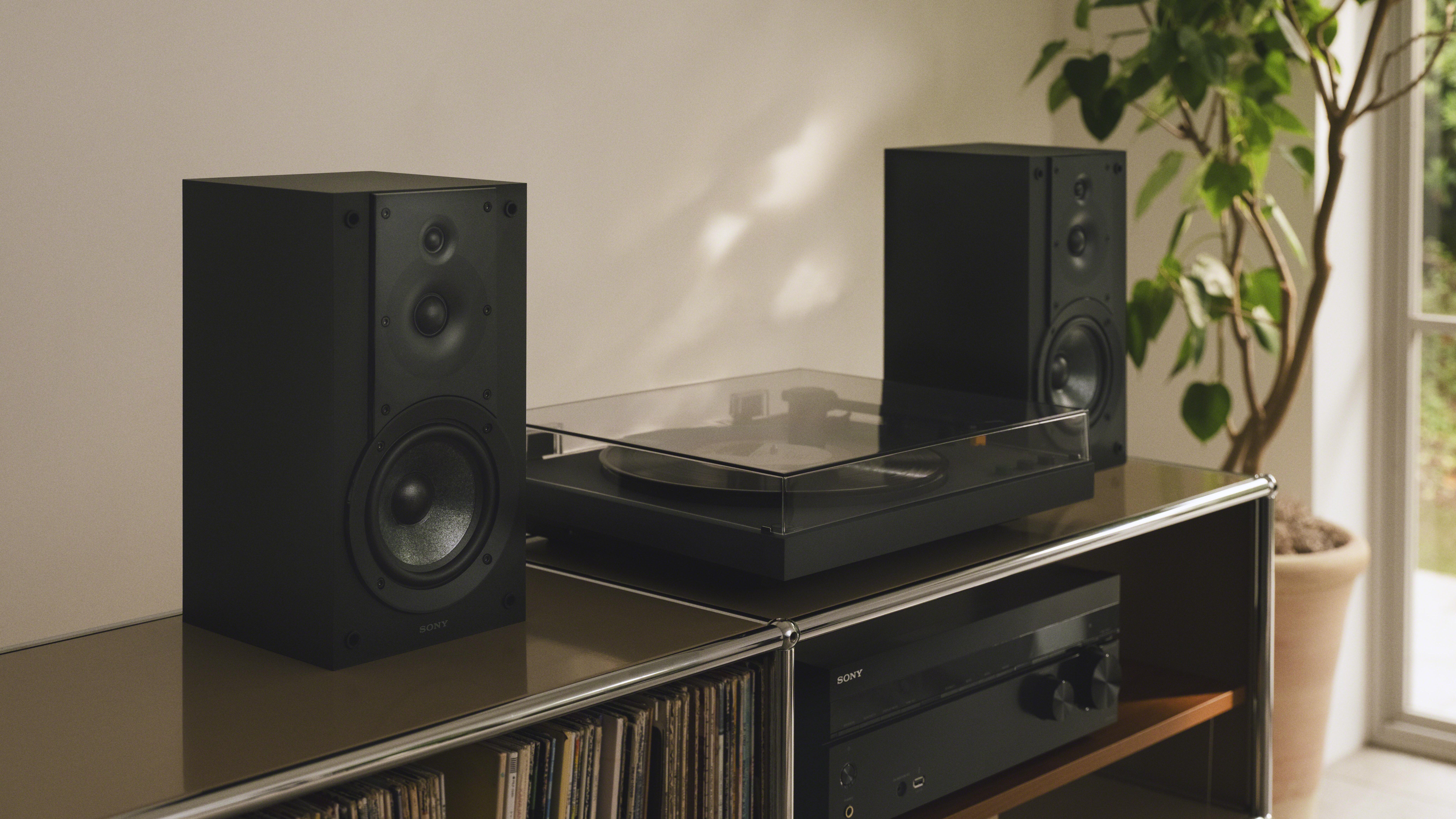 Sony PS-LX5BT with a set of bookshelf speakers above a vinyl filing system and amplifier
