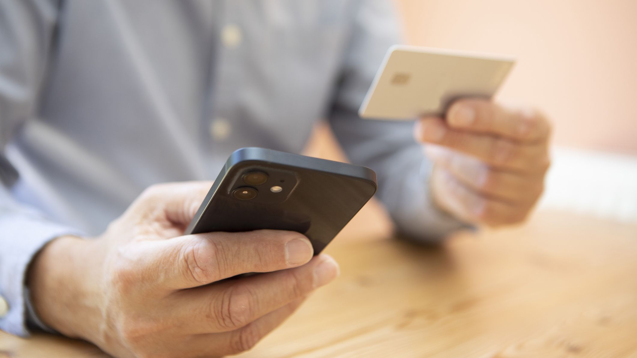 Close up of man holding a cell phone and credit card