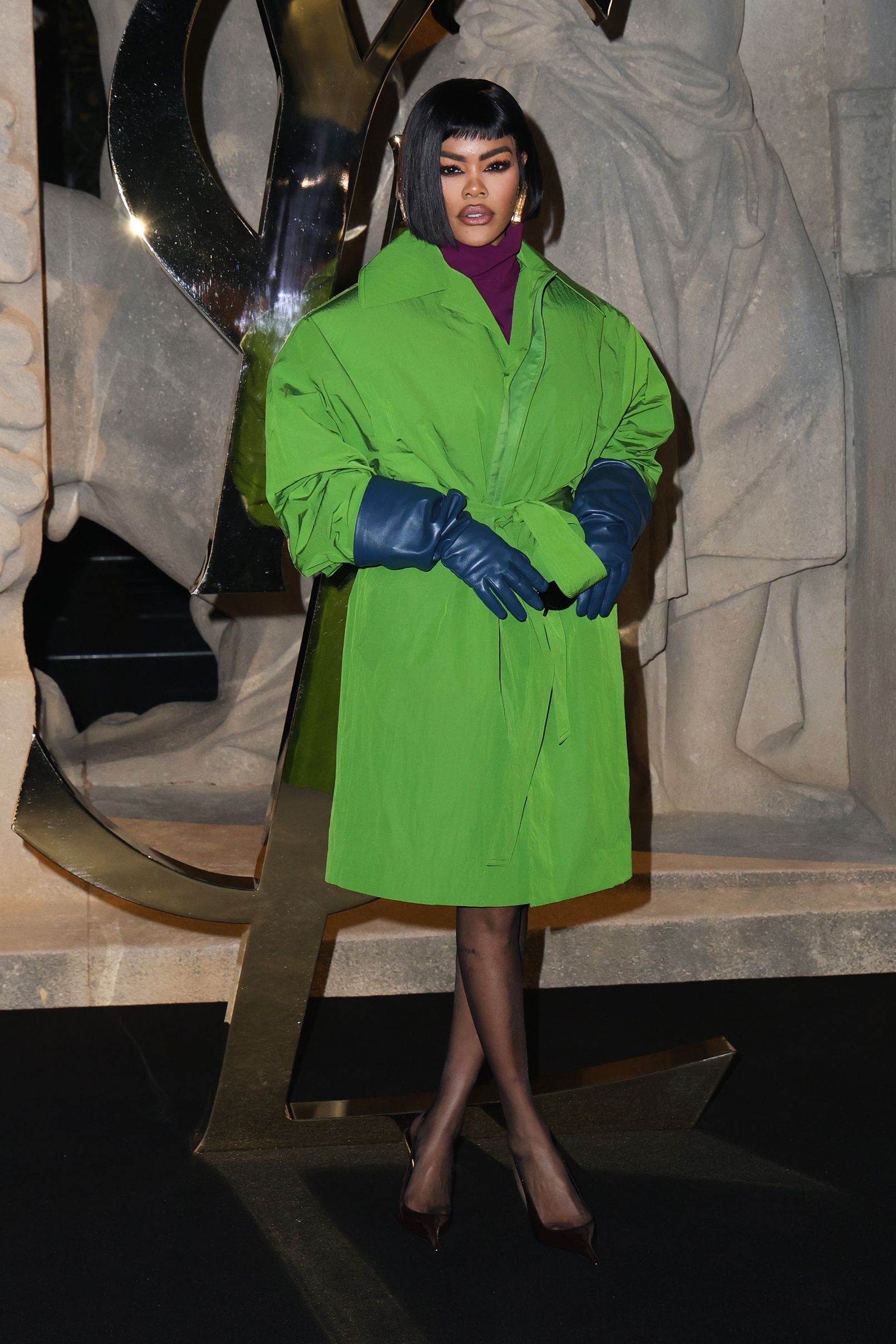 teyana taylor wearing a green coat with blue gloves at the saint laurent show