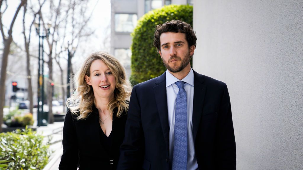 Elizabeth Holmes and Billy Evans leave a hearing outside wearing business clothes in March 2023 in San Jose, California.