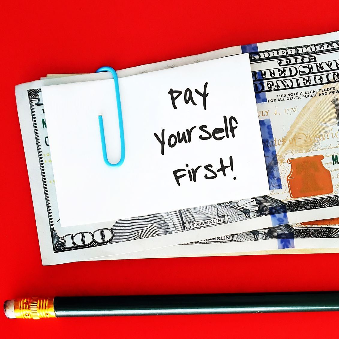 A stack of cash with a note paper clipped to it that says 