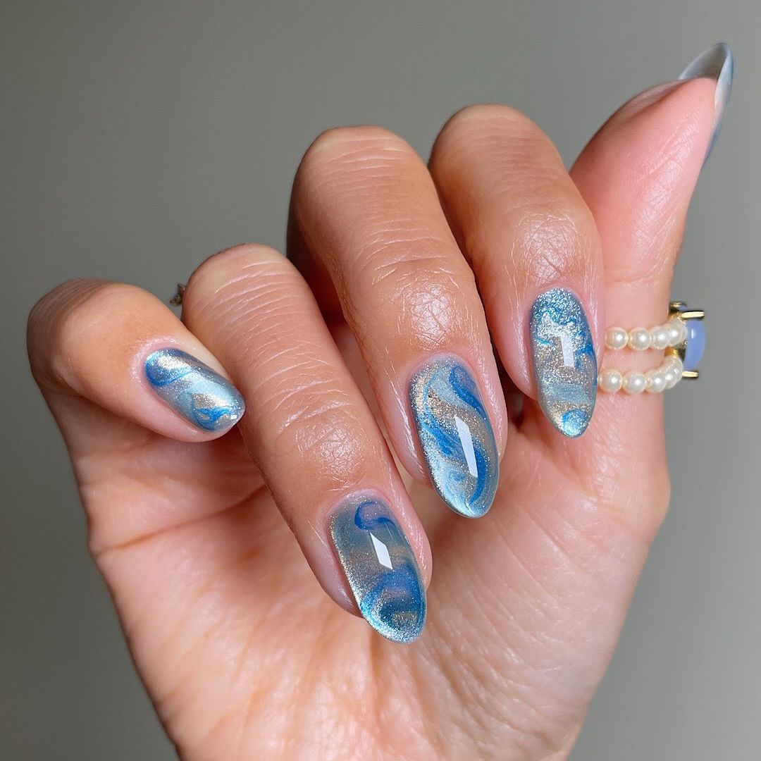 blue manicure with a glassy finish and swirls