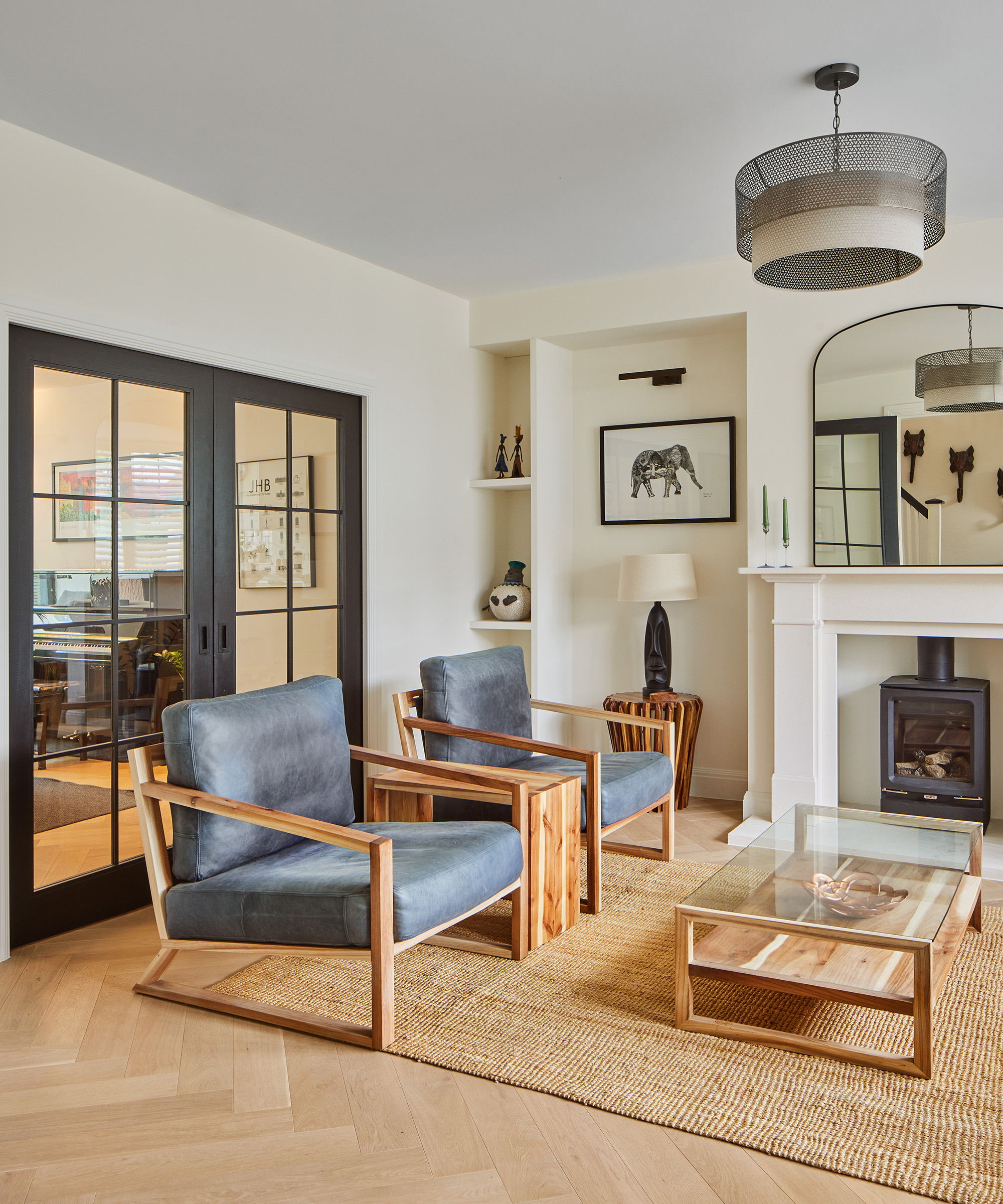 A Japandi style living room with two armchairs with fireplace and glass doors