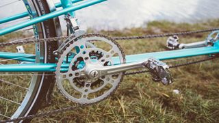 A tandem chainset with a large silver chainring and a much smaller black inner chainring