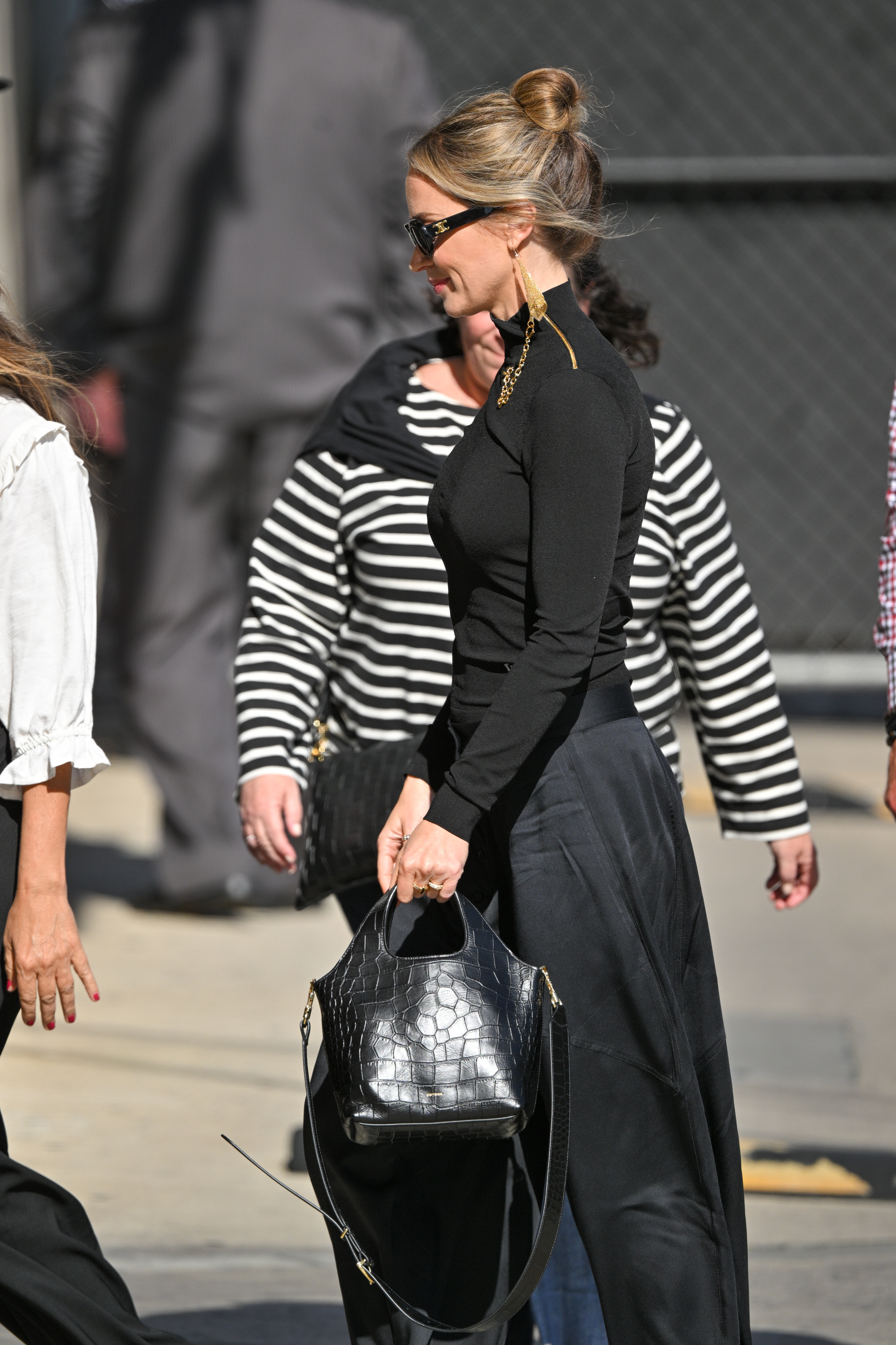 Emily Blunt holding a black croc-embossed System Tote from Cuyana.
