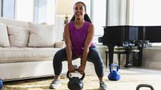 Woman exercising at home with kettlebells