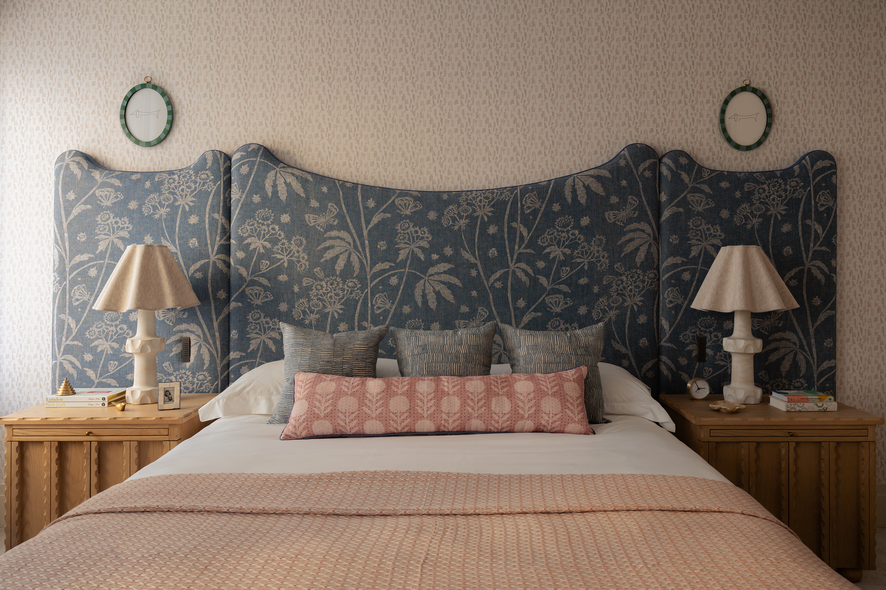 bed with scalloped headboard and blue fabric cover