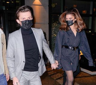 Tom Holland and Zendaya walking hand in hand in masks