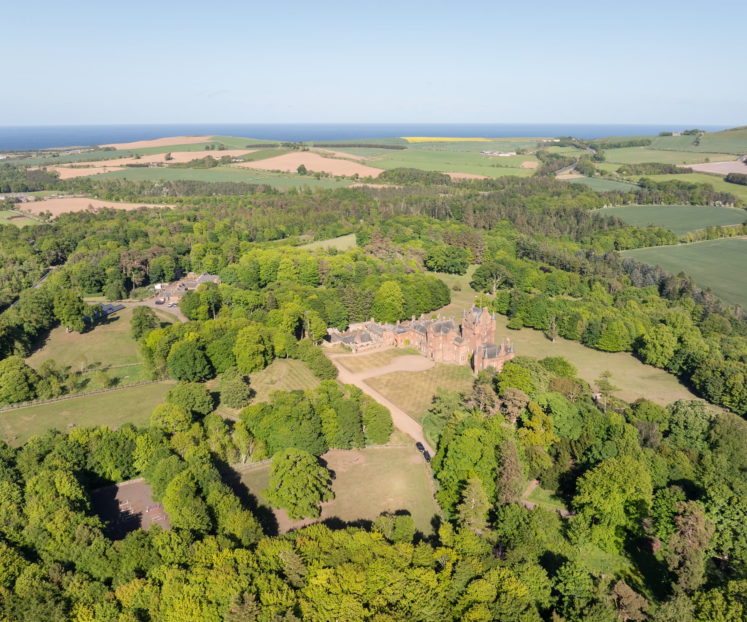 An overhead shot of a castle and its grounds surrounded by trees