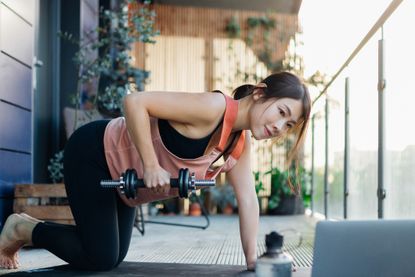 best dumbbells for women - young Asian woman exercising with dumbbells outside