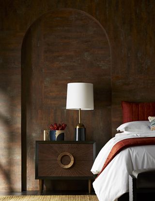 contemporary bedroom with alcove, white lamp, red and white bedding, textured walls