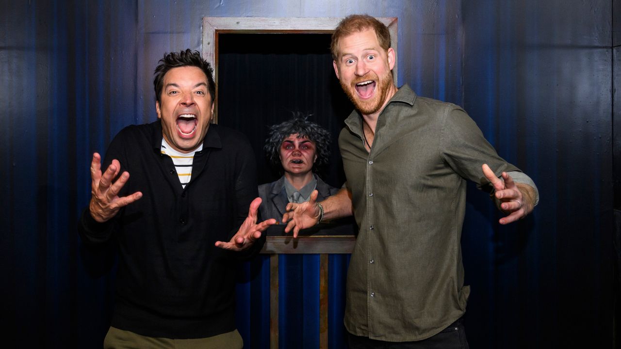 Prince Harry and Jimmy Fallon screaming in a haunted house with a creepy character behind them