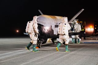 Technicians work with the recently landed robotic X-37B at NASA's Kennedy Space Center in Florida on Nov. 12, 2022.
