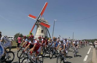 The Tour de France peloton passes a windmill