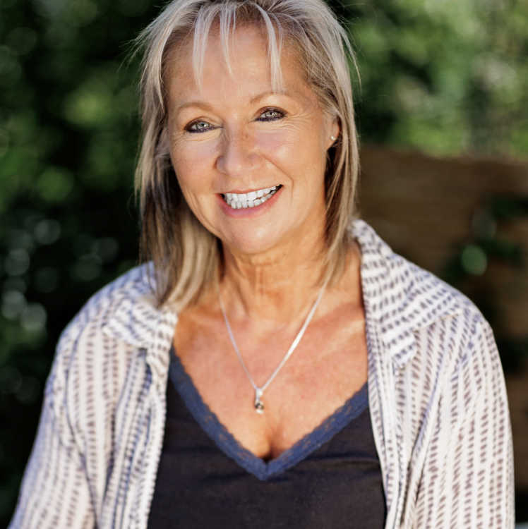 A headshot of a woman with blonde hair smiling at the camera
