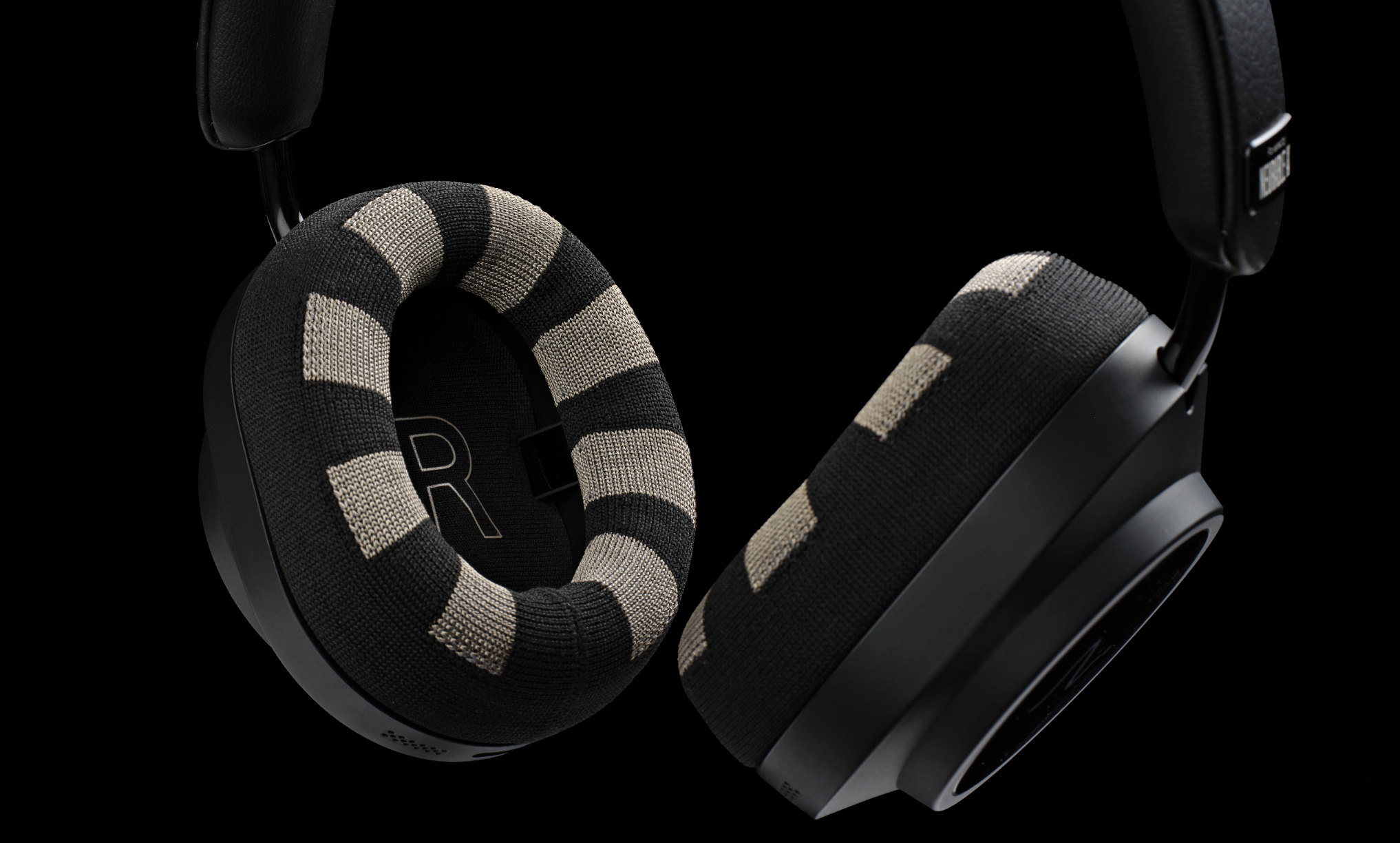 Neurable One headphones on a wooden desk, or on a black background, showing the ear cups