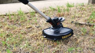 Black + Decker LSTE525 in use on patch of grass