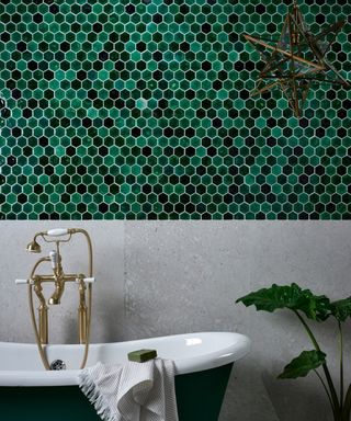 small mosaic tiles on bathroom wall in shades of dark green