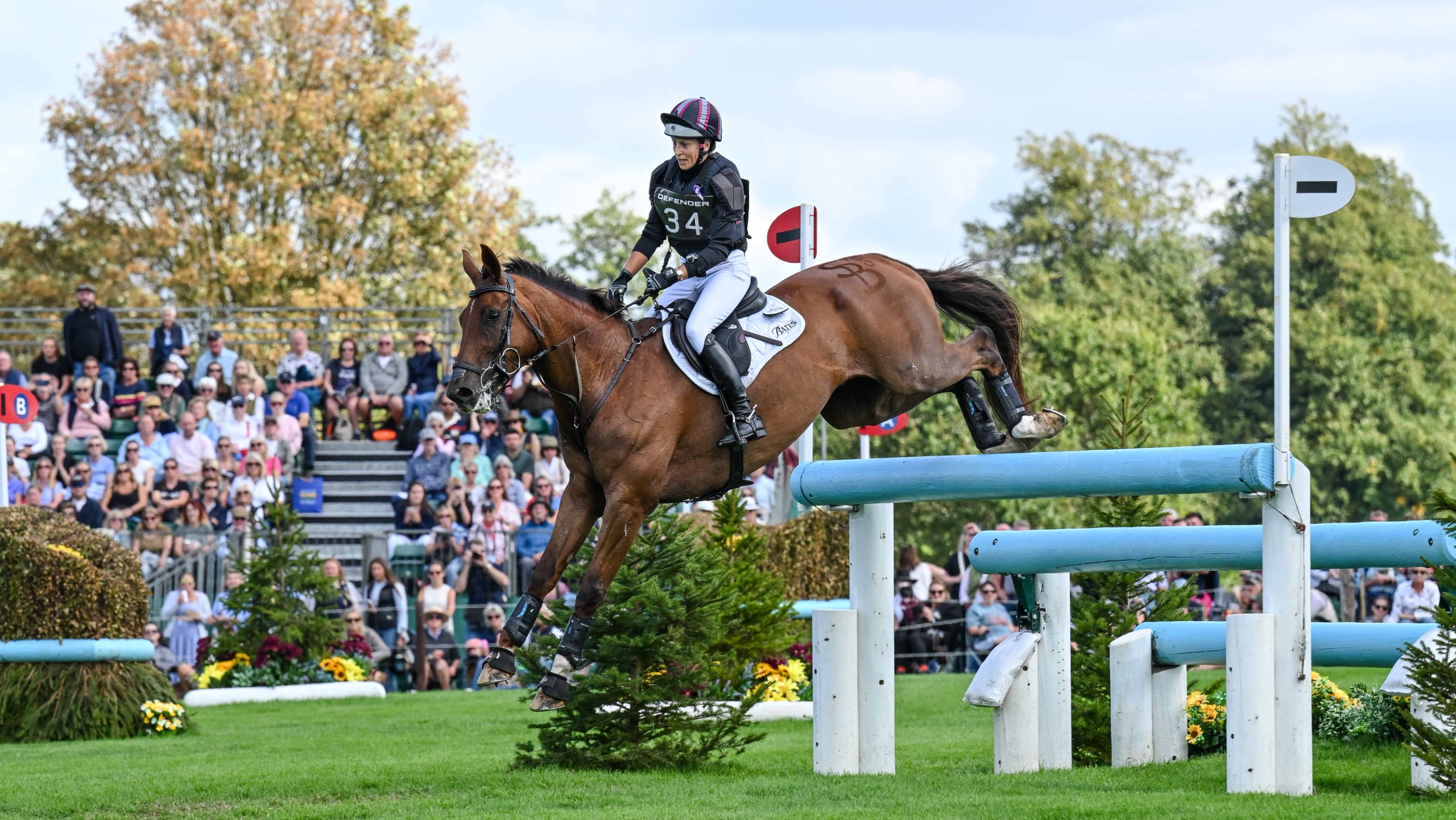 Sarah Bullimore in black and purple colours clears a fence on her horse Corimiro at the 2026 Defender Burghley Horse Trials