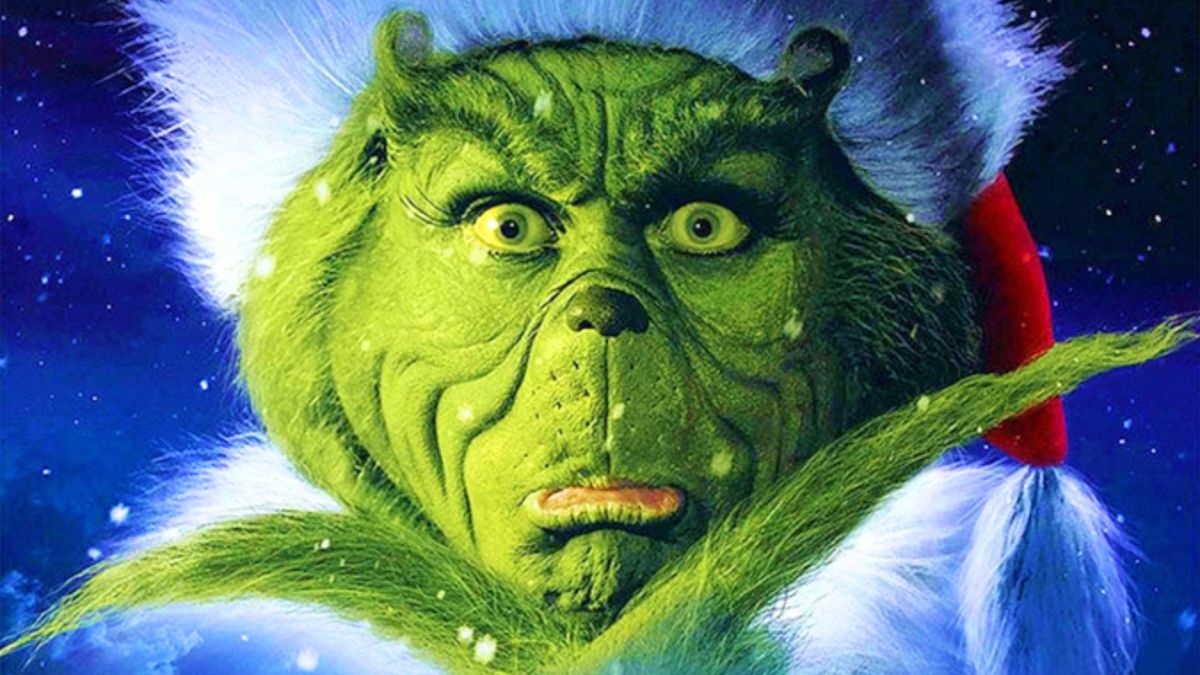 Best Christmas movies: A close-up of Jim Carrey as the Grinch wearing a Santa hat during How the Grinch Stole Christmas.