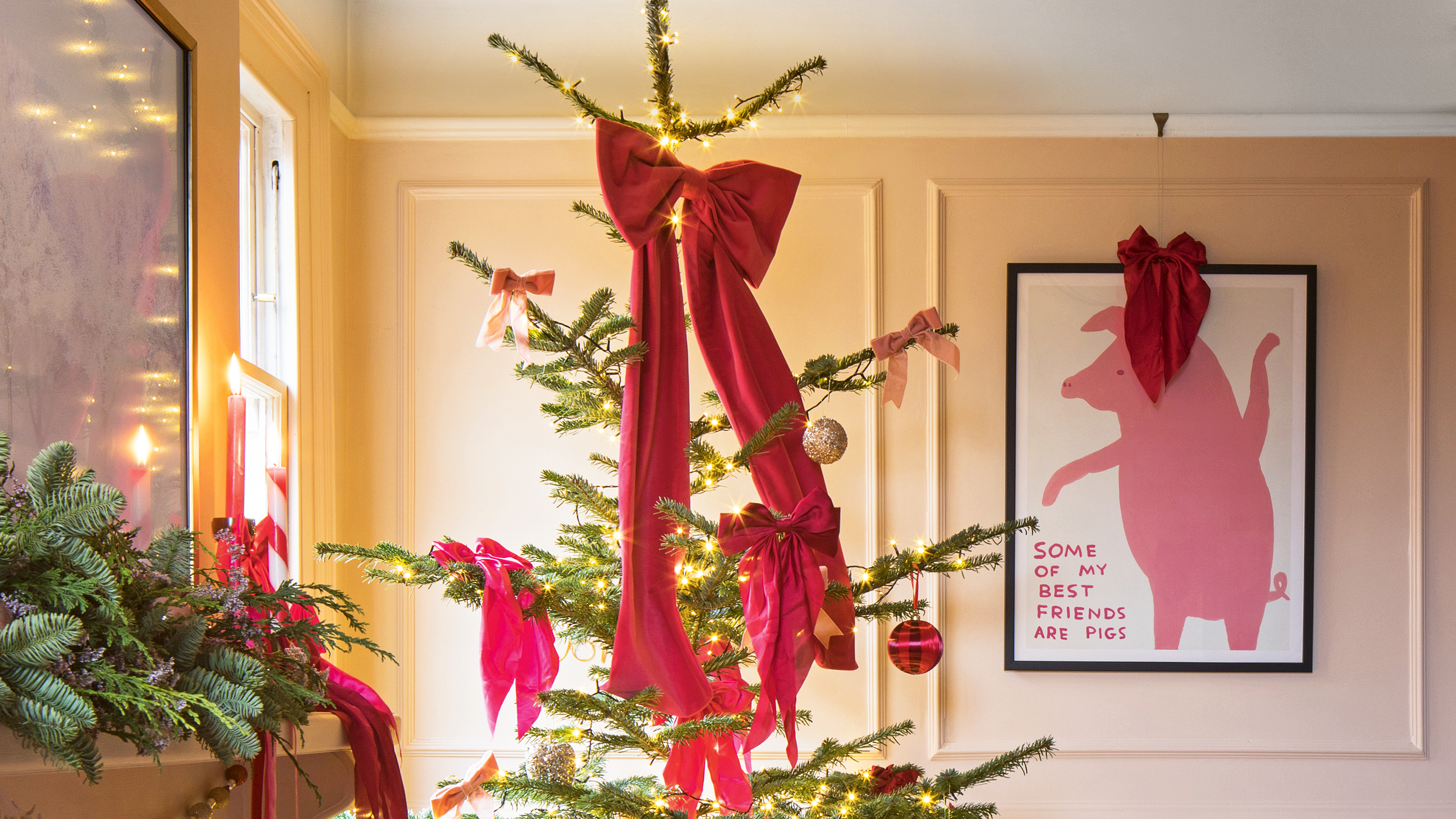 Christmas tree covered with oversized red bows in a pink living room