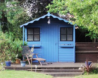 Blue shed with deck and garden chair