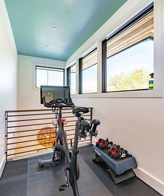 A small home gym in a narrow space with light blue ceiling